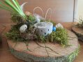 eine Baumscheibe mit Moos und kleinem Osterhasen dekoriert
