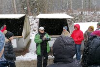 Personen in Winterjacken vor Müllcontainer