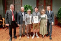 6 Personen stehen in einem Saal nebeneinander