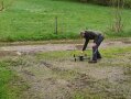 Ein Mann bedient eine Agrardrohne auf einer Wiese.