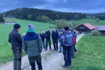 Die Teilnehmer der Feldergegehung stehen in einer Runde an einem Feldweg.