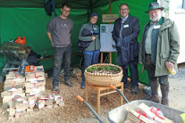 Vier Personen stehen an Stand nebeneinander