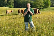 Landwirt auf Wiese mit Kühe im Hintergrund